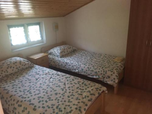 a bedroom with two beds and a window at Apartman Antonia in Podhum