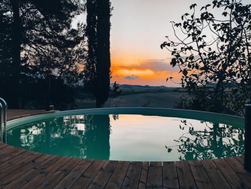 a swimming pool with a sunset in the background at Villa Maiano Casa Piccola in Torretta