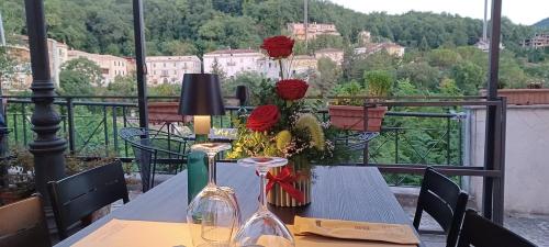 a table with flowers and wine glasses on a balcony at Atina House - Centro Storico in Atina
