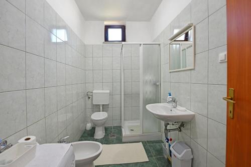 biała łazienka z toaletą i umywalką w obiekcie Apartmani Irena Arvaj w Poreču