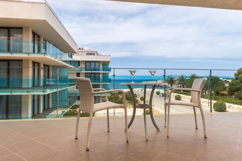 a table and chairs on a balcony with a view of the ocean at Aparthotel Caprice Skyline in Ciutadella