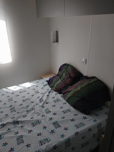 une chambre avec un lit avec une couette dessus dans l'établissement MH 285 O'HARA 3 chambres et 1 salle de bain dans camping 4 étoiles, à Saint-Julien-en-Born