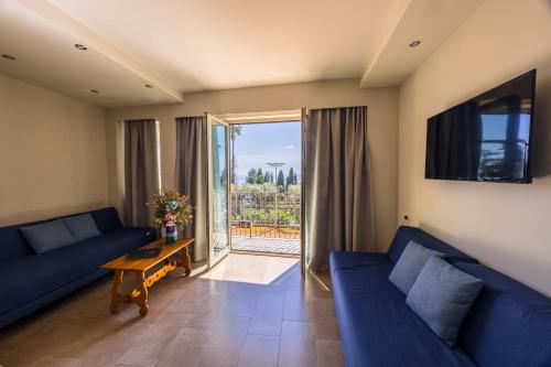a living room with two blue couches and a table at Hotel Villa Paradiso in Taormina