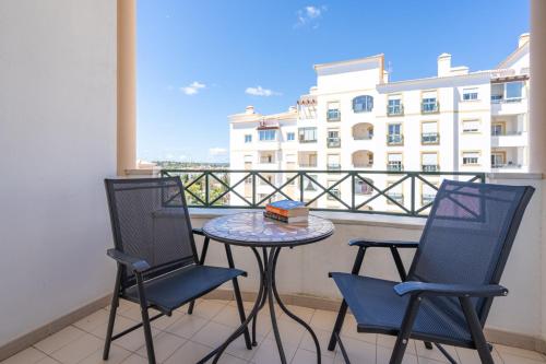 einen Tisch und Stühle auf einem Balkon mit Blick auf ein Gebäude in der Unterkunft Two Bedroom Apartment - 110m2, AC, Terrace, Wi-Fi in Lagos