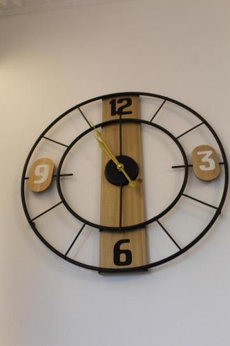 a clock is hanging on a white wall at Κatholikis Room in Kremasti