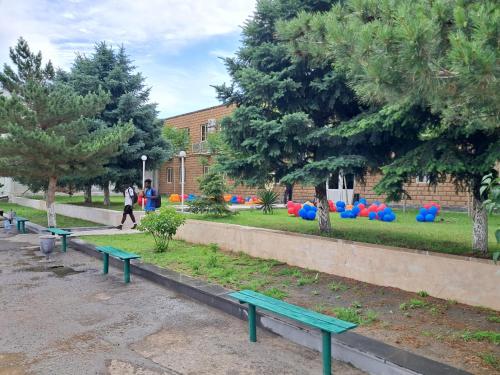a row of green benches in a park at Ayg Hotel and Sport Complex Ararat in Davalinskiy Tsemzavod