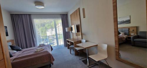 a hotel room with a bed and a mirror at Apartament Czarna Góra Silver in Sienna