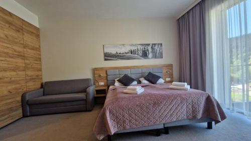 a bedroom with a bed and a chair and a window at Apartament Czarna Góra Silver in Sienna