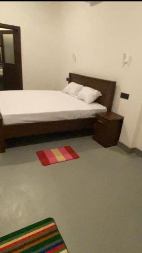 a bedroom with a bed and a rug on the floor at Evergreen garden in Nilwella