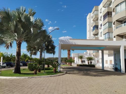 a gas station with palm trees in front of a building at Confortável Apto de 2 Quartos - Lagoa Quente in Caldas Novas