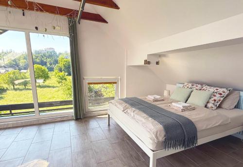 a bedroom with a bed and a large window at Deerwood-Sky Attic with Bled Castle View-NO KITCHEN in Bled