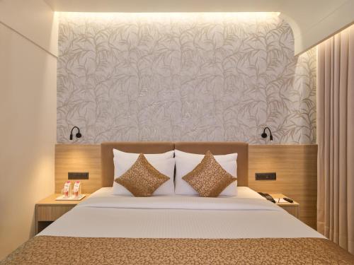 a bedroom with a large bed with a large wall at Biznotel By Pride Motera in Ahmedabad