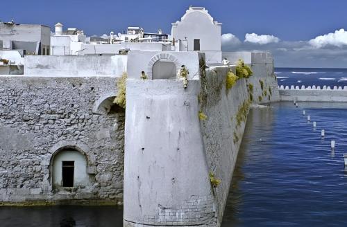 a stone wall with water next to a body of water at Appartement Vintage full équipé EL JADIDA in El Jadida