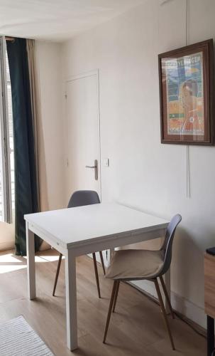 - une table blanche et une chaise dans la chambre dans l'établissement Appartement 2 pièces 42m2 - Puces de Saint-Ouen, à Saint-Ouen