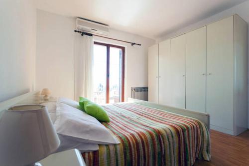 una camera da letto con un letto con cuscini verdi e una finestra di Holiday Home Platanus a Trsteno