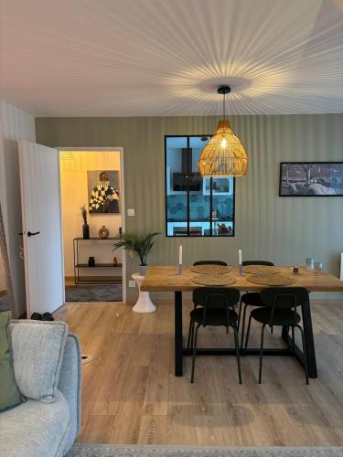 une table à manger avec des chaises et un lustre dans l'établissement Lucky luke appartment, à Strasbourg
