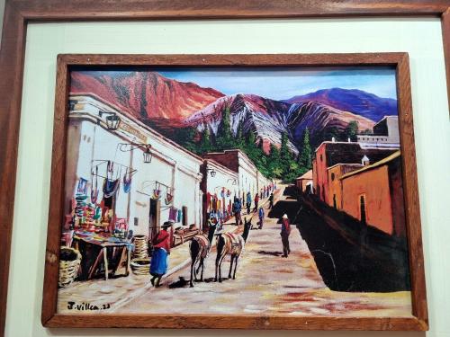 a painting of a street with people and horses walking down a street at Hotel y Restaurante Winu Maimara in Maimará