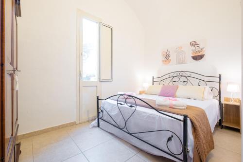 a bedroom with a bed with a metal frame at Villa Colabati - Private Pool near Gallipoli in Alezio