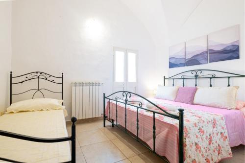 a bedroom with a bed with pink and pink sheets at Villa Colabati - Private Pool near Gallipoli in Alezio