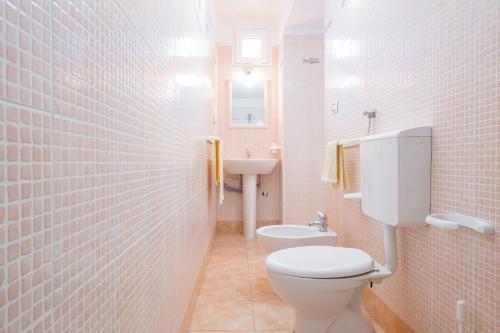 a bathroom with a toilet and a sink at Villa Colabati - Private Pool near Gallipoli in Alezio