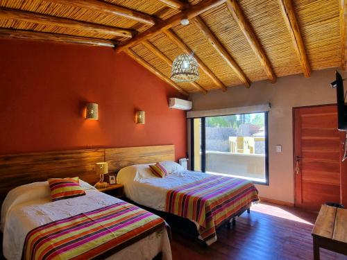 a bedroom with two beds and a window at Hotel y Restaurante Winu Maimara in Maimará