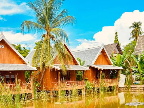 a row of cottages in a village with palm trees at The Jam Boutique Hotel in Luang Prabang