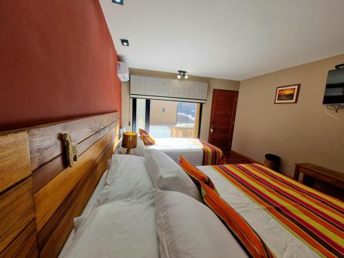 a hotel room with two beds and a window at Hotel y Restaurante Winu Maimara in Maimará