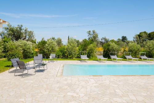 a group of chairs and a swimming pool at Villa Colabati - Private Pool near Gallipoli in Alezio