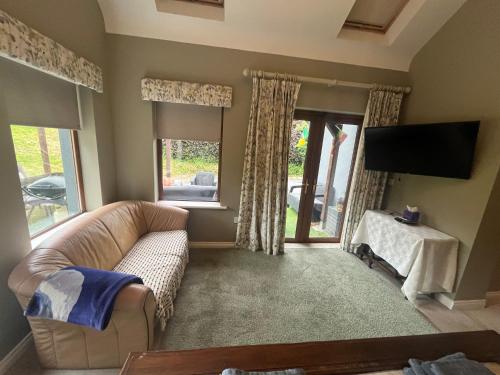 a living room with a couch and a flat screen tv at Castletown Carlow in Carlow