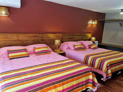 two beds sitting next to each other in a bedroom at Hotel y Restaurante Winu Maimara in Maimará
