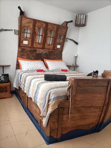 a bedroom with a bed with a wooden headboard at Ocean Pirate in Costa de Antigua