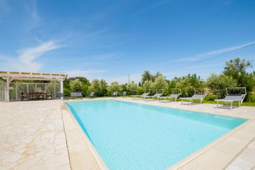 a swimming pool with chairs and a gazebo at Villa Colabati - Private Pool near Gallipoli in Alezio