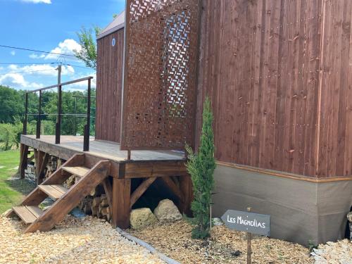 ein hölzernes Nebengebäude mit einem Holzzaun in der Unterkunft Cabane luxe & spa extérieur Les Magnolias in Barjou