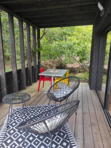 un patio avec deux chaises et une table sur une terrasse dans l'établissement Studio Nature & Calme, Lac et Forêt à Pied, à Lacanau