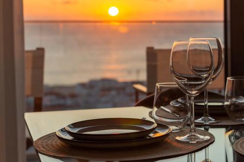 a table with a plate and two wine glasses at Caminho Real Guest Apartment I in Nazaré