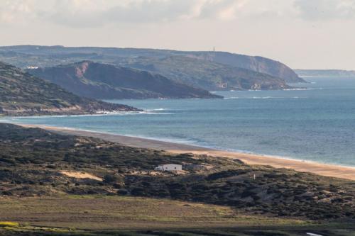 a view of a beach with a house and the ocean at Caminho Real Guest Apartment I in Nazaré