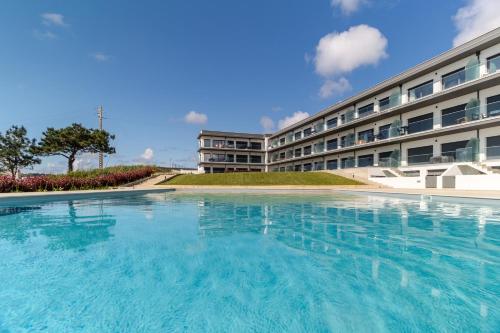 a swimming pool in front of a building at Caminho Real Guest Apartment I in Nazaré