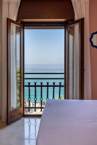 a bedroom with a view of the ocean at La Vista Postcard Hotel in Lazise