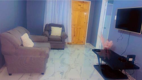 a living room with two couches and a flat screen tv at Wild Orchid Bloom-Blue Lemon in Mandeville