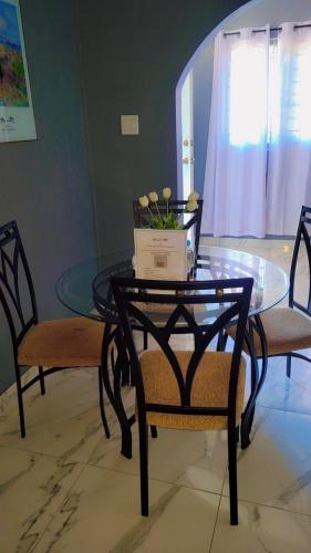 a glass table and two chairs with a laptop on it at Wild Orchid Bloom-Blue Lemon in Mandeville