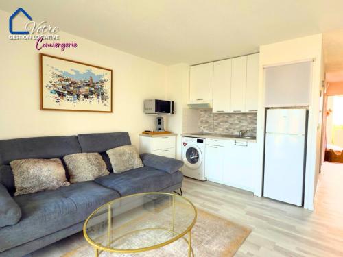 un salon avec un canapé et une cuisine dans l'établissement Le Roy Soleil de la Méditerranée, à Canet