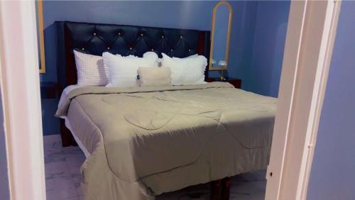a blue bedroom with a large bed with white pillows at Wild Orchid Bloom-Blue Lemon in Mandeville