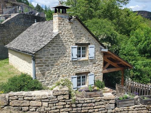 a stone house with a chimney on top of a stone wall at Chez Lucette in Barjac