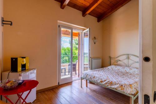 a bedroom with a bed and a sliding glass door at Casa Jo - Country Home with Sea View and 3 Private Ensuite Rooms in Lapedona