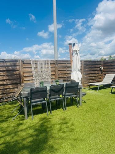 a garden with a table and chairs on the grass at Spacieux & cozy, wifi gratuit, parking, proximité plage 15 min in Puget-sur Argens