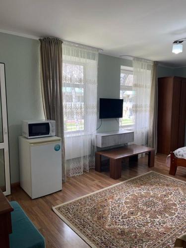 a living room with a television and a couch at Квартира в Радуга Плюс in Chon-Sary-Oy
