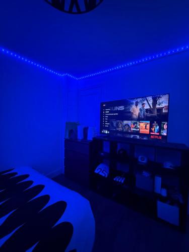 un salon avec une chambre bleue et une télévision dans l'établissement Appartement Saint Ferdinand, à Paris