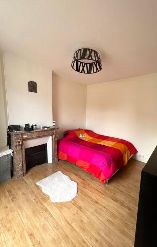 - une chambre avec un lit coloré et une cheminée dans l'établissement Appartement Saint Ferdinand, à Paris