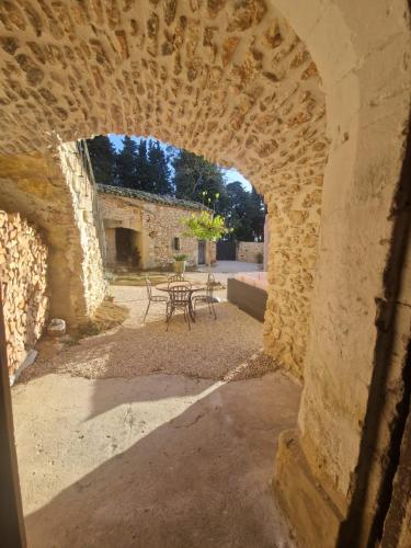 une arche dans un bâtiment en pierre avec une table et des chaises dans l'établissement Le Mas des 3 Roches proche d'Uzès, à Pougnadoresse