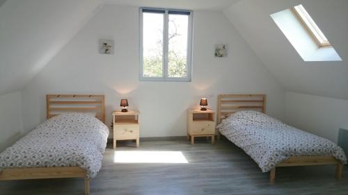 - 2 lits dans une chambre avec fenêtre dans l'établissement Gîte Les Sources de l'Andelle, à La Ferté-Saint-Samson
